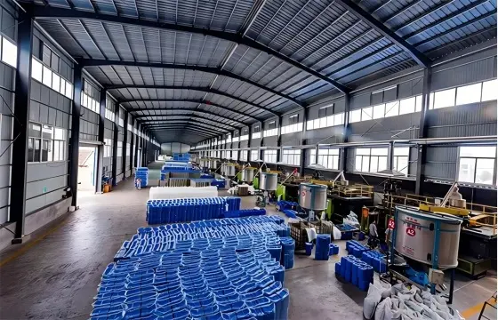 宽敞的钢结构生产车间内，整齐堆放大量蓝色塑料桶，各类化工配套生产设备有序排布，采光充足，水玻璃主要应用于建筑、耐火材料、铸造、造纸、纺织、石油、化工、土壤固化及防水堵漏等行业。。